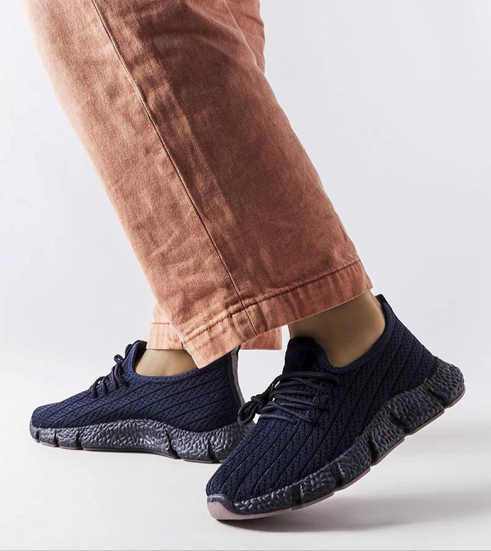 Person wearing Arvène Navy Summer Sport Sneakers with breathable textile, lace-up design, and rubber sole, perfect for warm weather walks.