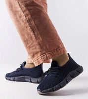 Person wearing Arvène Navy Summer Sport Sneakers with breathable textile, lace-up design, and rubber sole, perfect for warm weather walks.