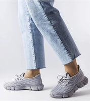 Woman wearing Armonia Gray Summer Sport Sneakers with lace-up front and rubber soles, paired with light denim jeans for casual style.