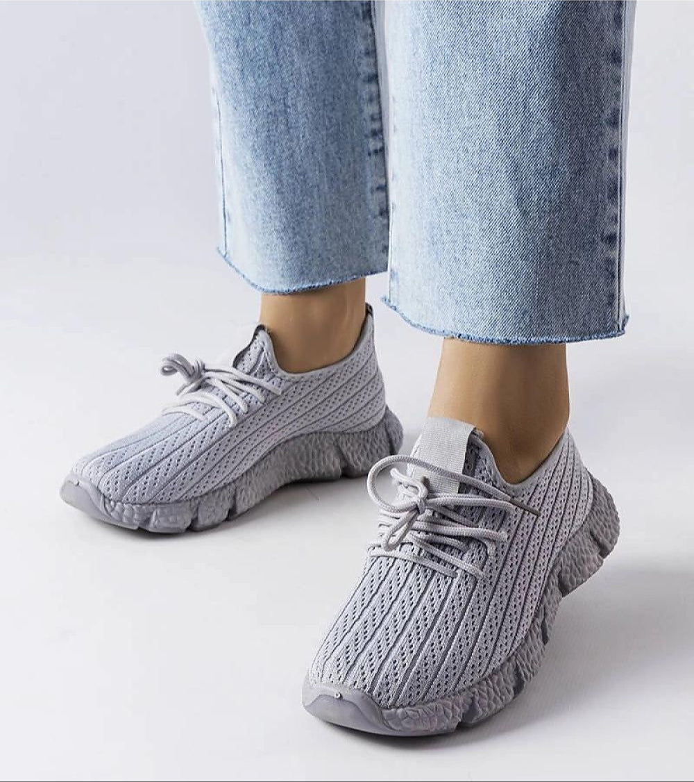 Person wearing Armonia Gray Summer Sport Sneakers with a breathable textile upper, paired with jeans, ideal for warm weather comfort and style.