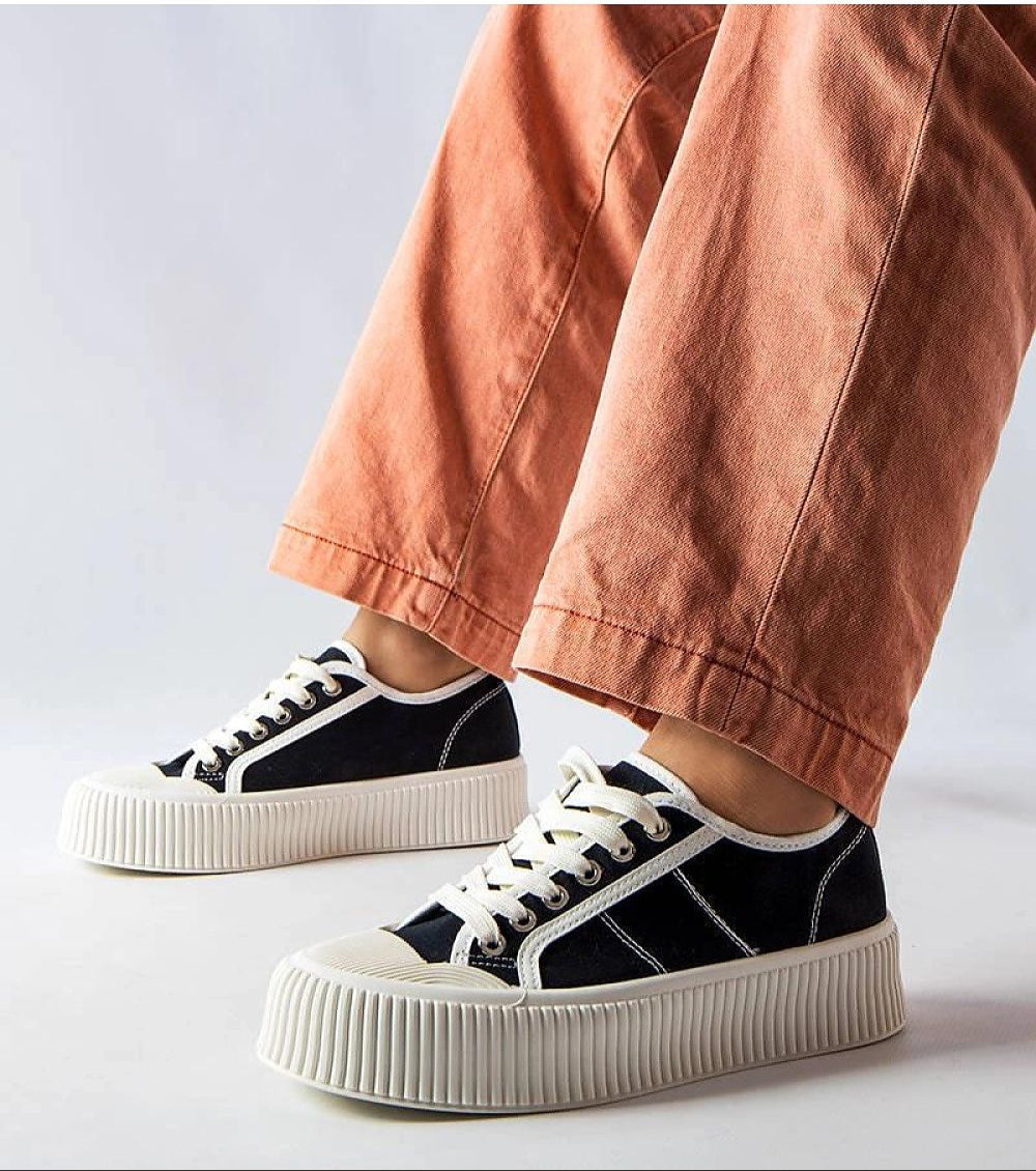 Person wearing Castisca Black Fabric Platform Sneakers with white rubber soles, paired with orange wide-leg pants.