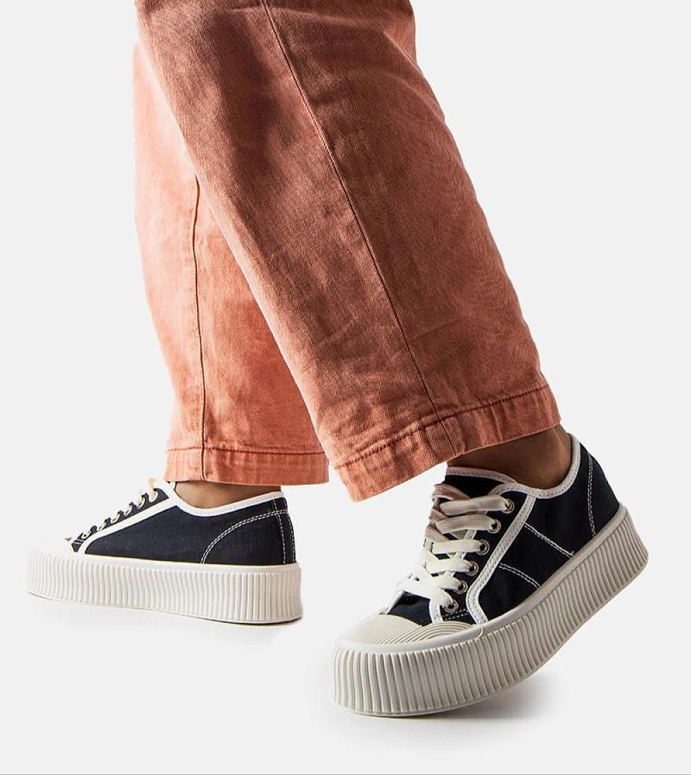 Model wearing Castisca black fabric platform sneakers with thick white rubber soles, showcasing urban style and summer comfort.