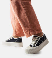 Model wearing Castisca black fabric platform sneakers with thick white rubber soles, showcasing urban style and summer comfort.