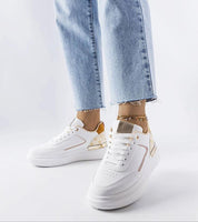 Marriale white sneakers with beige details, featuring a lace-up front and rubber sole, styled with blue jeans for a casual look.