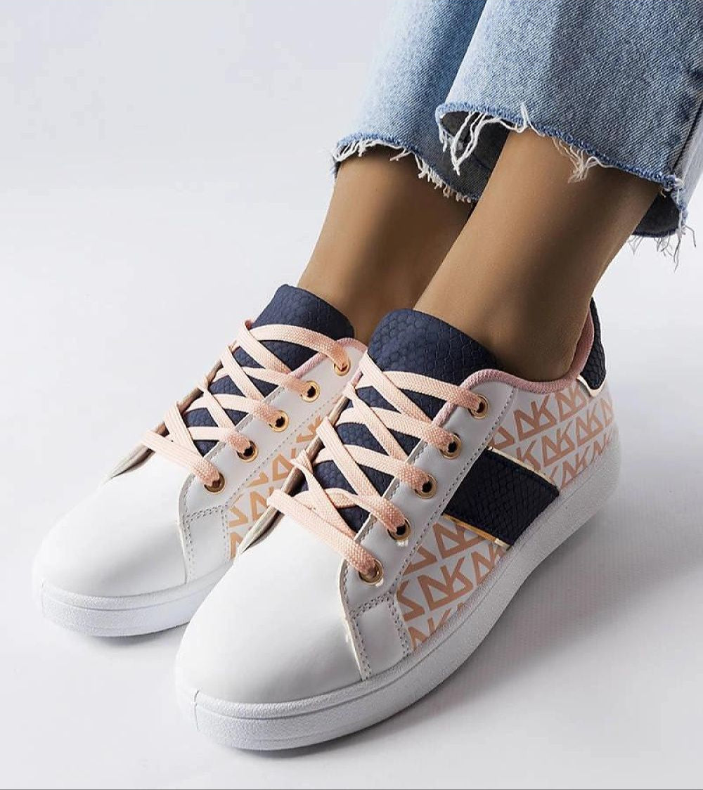 Woman wearing Alelya Doringer StrideGlow Sneakers with white eco-leather and colorful designs, paired with blue jeans.
