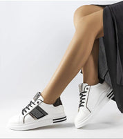 Woman wearing Meralla Rhinestone Platform Sneakers with rhinestone details, showcasing a chic sporty style against a white background.