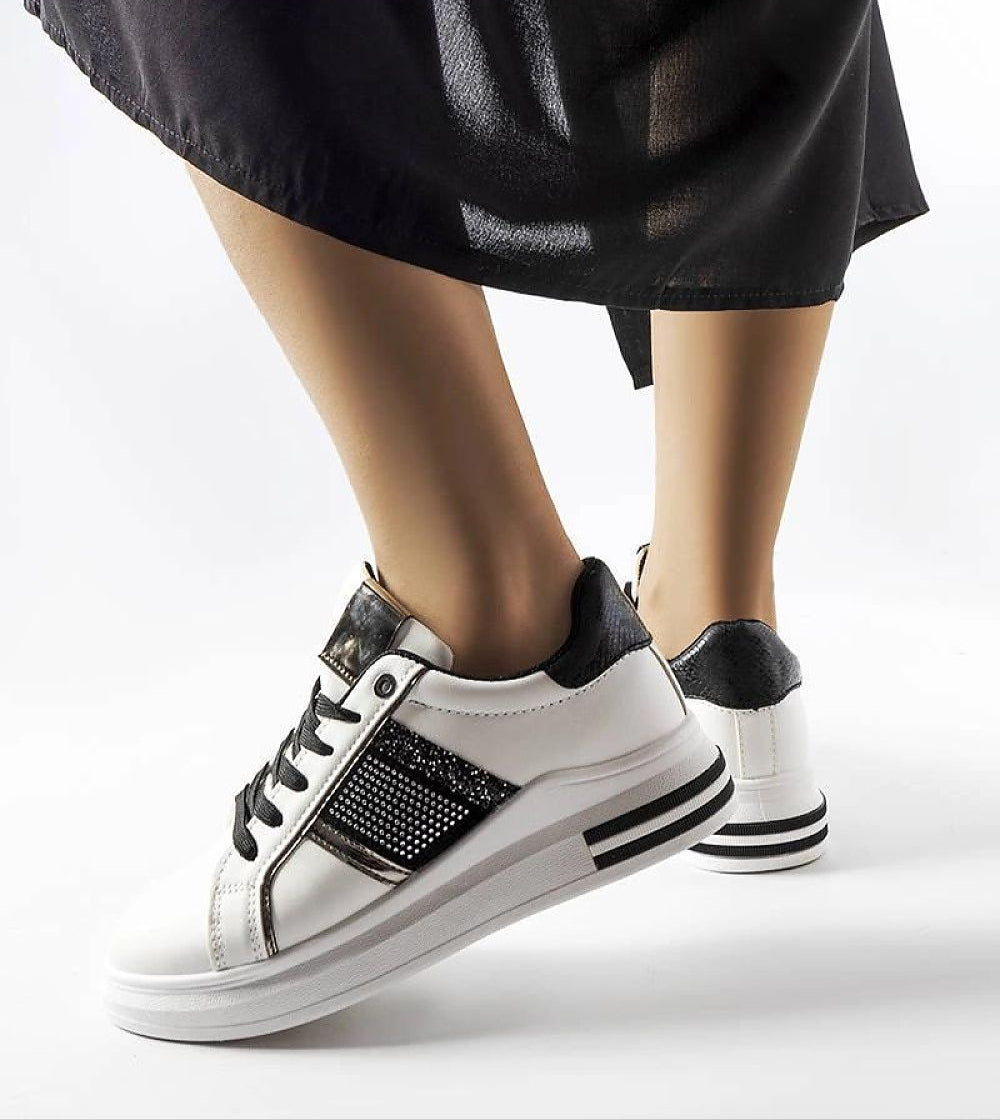 Woman wearing Meralla Rhinestone Platform Sneakers in white with black details, featuring a 4 cm sole for stylish urban or casual wear.