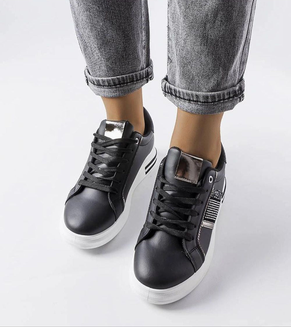 Woman wearing Meralla Rhinestone Platform Sneakers with black laces and jeans, showcasing the glittering details and 4 cm white sole.