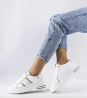 Meralla Rhinestone Platform Sneakers in beige with shimmering rhinestone details, worn by a model in jeans, showcasing sporty elegance.
