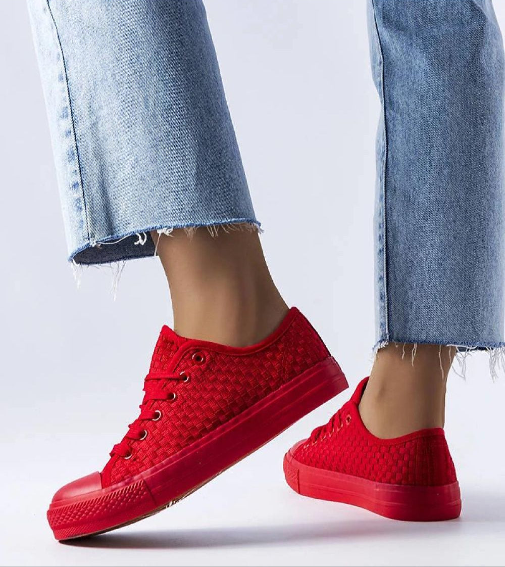 Person wearing red Revarya woven lace-up summer sneakers with frayed hem jeans.