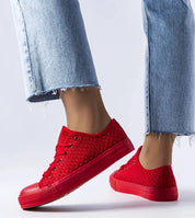 Person wearing red Revarya woven lace-up summer sneakers with frayed hem jeans.