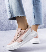 A person wearing Ismerra Suede Platform Lace Sneakers in pink with a soft eco suede upper and sculpted white platform sole.