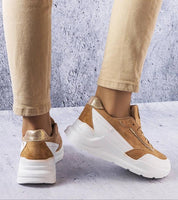 Ismerra suede platform lace sneakers in tan with eco suede upper, shown on person wearing beige pants, featuring sculpted sole and lace-up design.