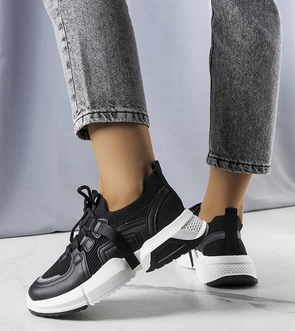 Person wearing Nyvelta black stretch knit sneakers with platform sole, showcasing slip-on style and flexible comfort.