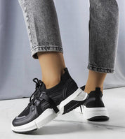 Person wearing Nyvelta black stretch knit sneakers with platform sole, showcasing slip-on style and flexible comfort.