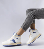 Person wearing Ormelya high-top sneakers with eco leather upper and secure lace-up front, styled with casual gray jeans.
