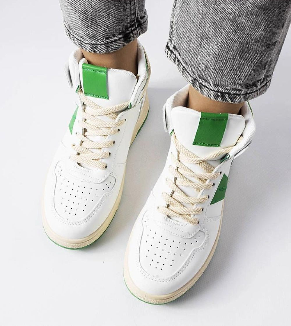 Person wearing Ormelya high-top sneakers in white with green accents, showcasing eco leather upper and secure lace-up design.