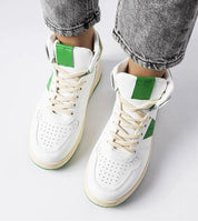 Person wearing Ormelya high-top sneakers in white with green accents, showcasing eco leather upper and secure lace-up design.