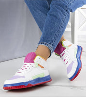 Colorful ankle sneakers with vibrant sole and suede effect, worn with rolled jeans, featuring lace-up closure and eco-leather design.