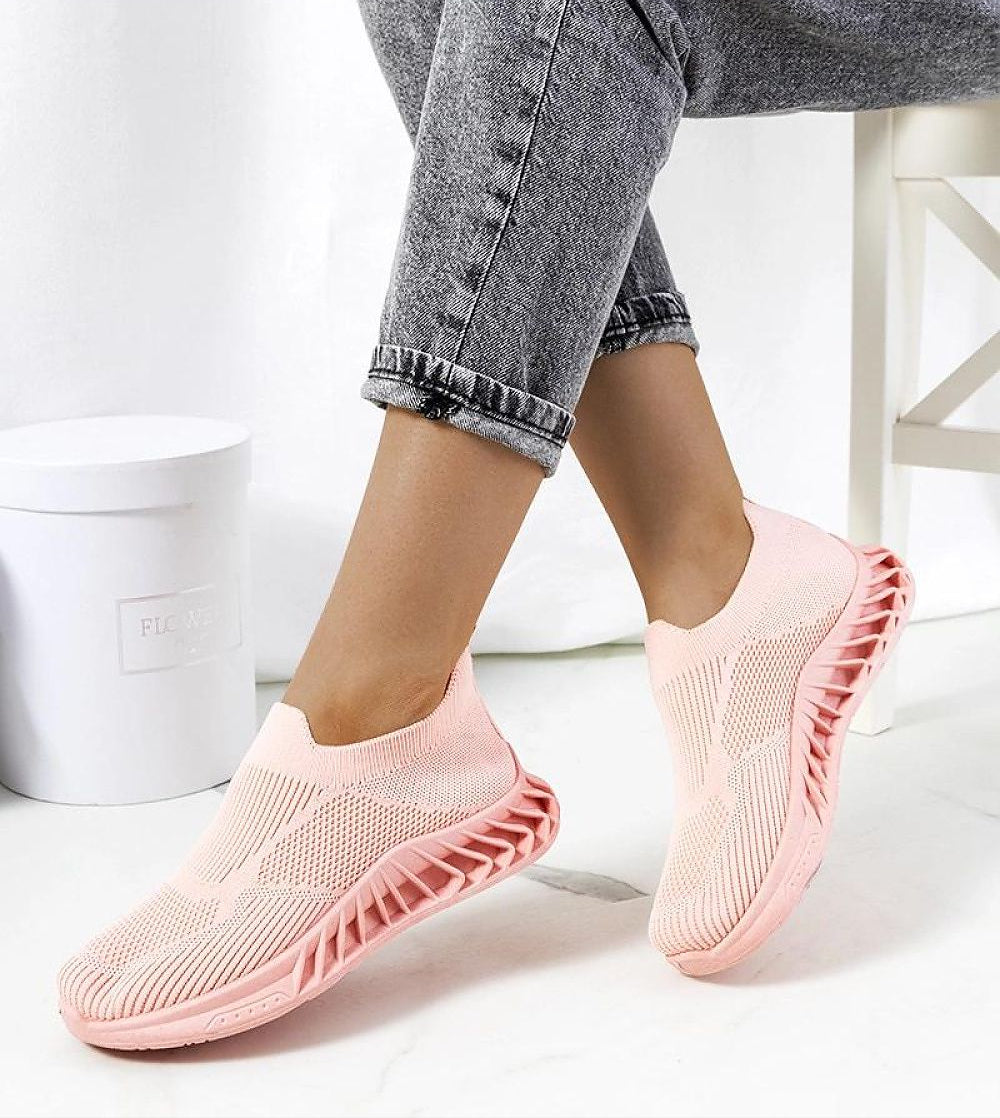 Person wearing Zavella Slip-On Sport Knit Sneakers in pink, showcasing breathable textile design and flexible silhouette for summer.