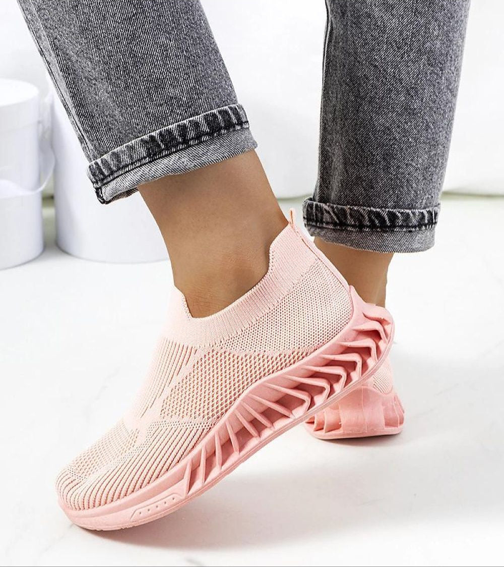 Woman wearing Zavella Slip-On Sport Knit Sneakers in pink, showcasing breathable textile and flexible sole design for summer comfort.