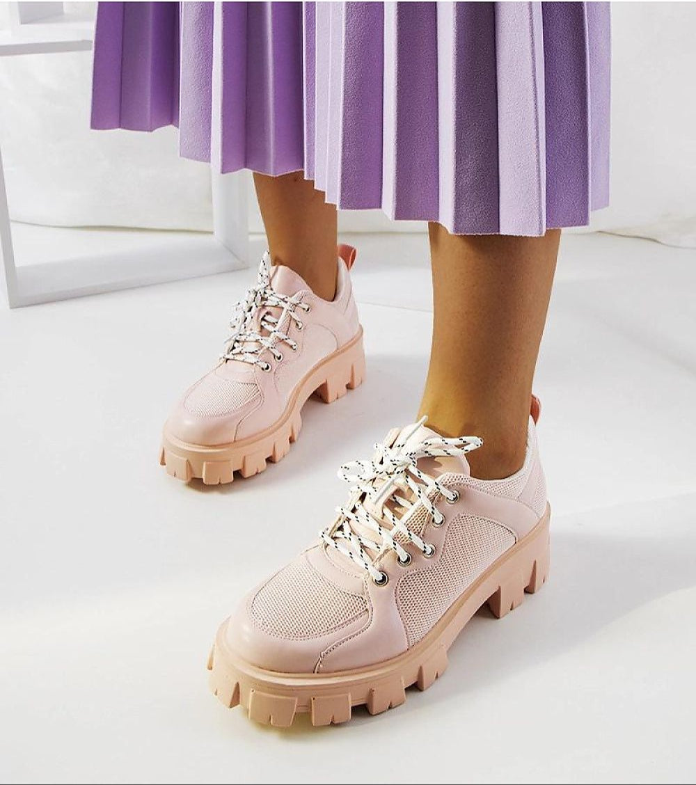 Person wearing Aurenza Daywalk Platform Sneakers with purple pleated skirt, showcasing pink chunky sole design and lace-up closure.