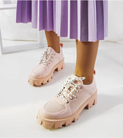 Person wearing Aurenza Daywalk Platform Sneakers with purple pleated skirt, showcasing pink chunky sole design and lace-up closure.