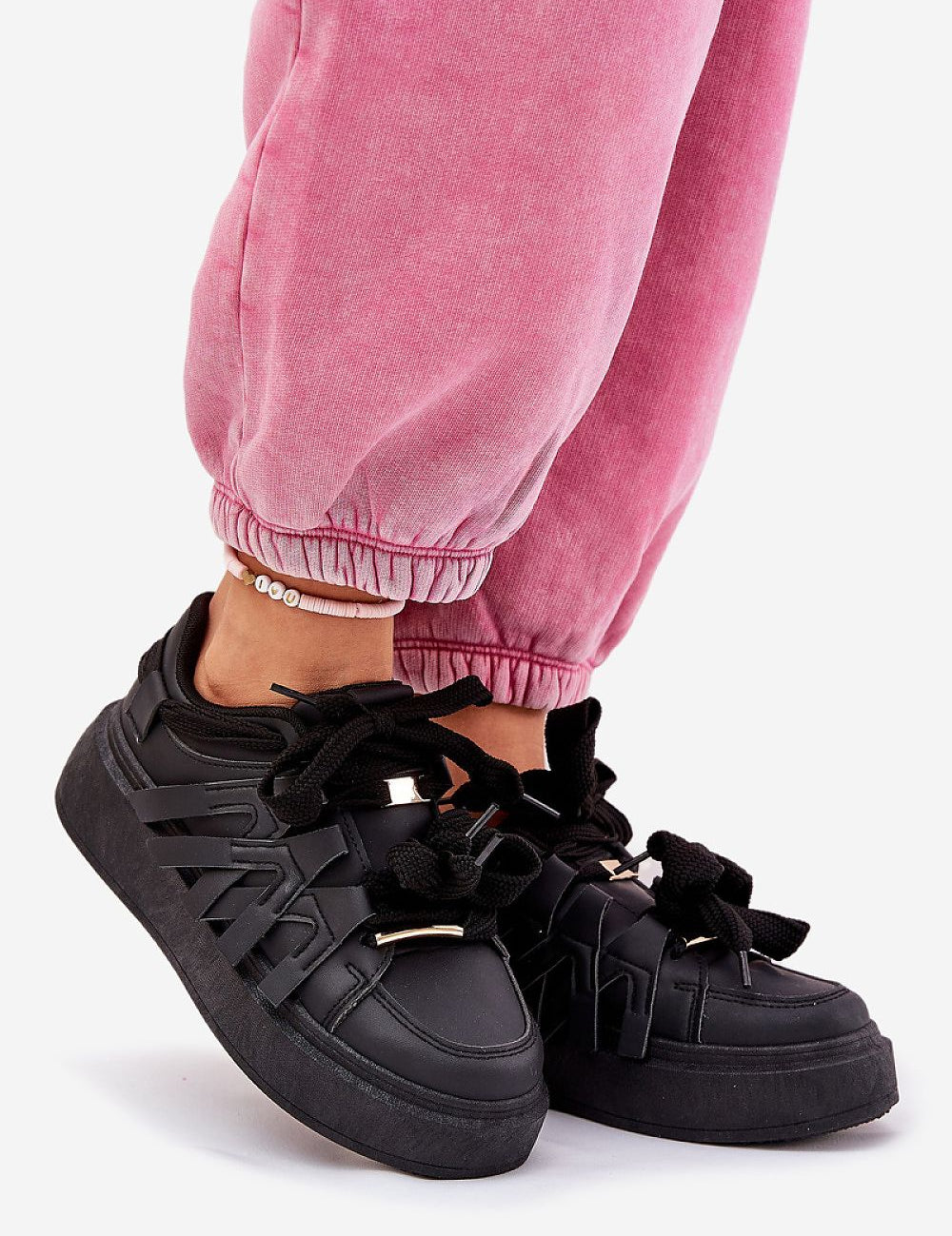 Person wearing Cernia Synthetic Platform Lace Sneakers in black with pink joggers, highlighting streetwear style and comfort.