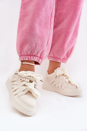 Woman wearing Cernia Synthetic Platform Lace Sneakers with pink joggers, showcasing streetwear style and platform sole design.