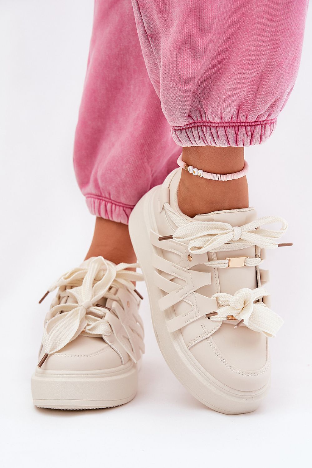 Cream Cernia Synthetic Platform Lace Sneakers with thick soles and solid lacing, styled with pink pants for a chic streetwear look.