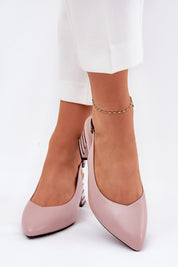 Woman wearing pink Elorelle column-heel sandals with pointed toe and ankle strap, styled for elegant daywear and evening events.