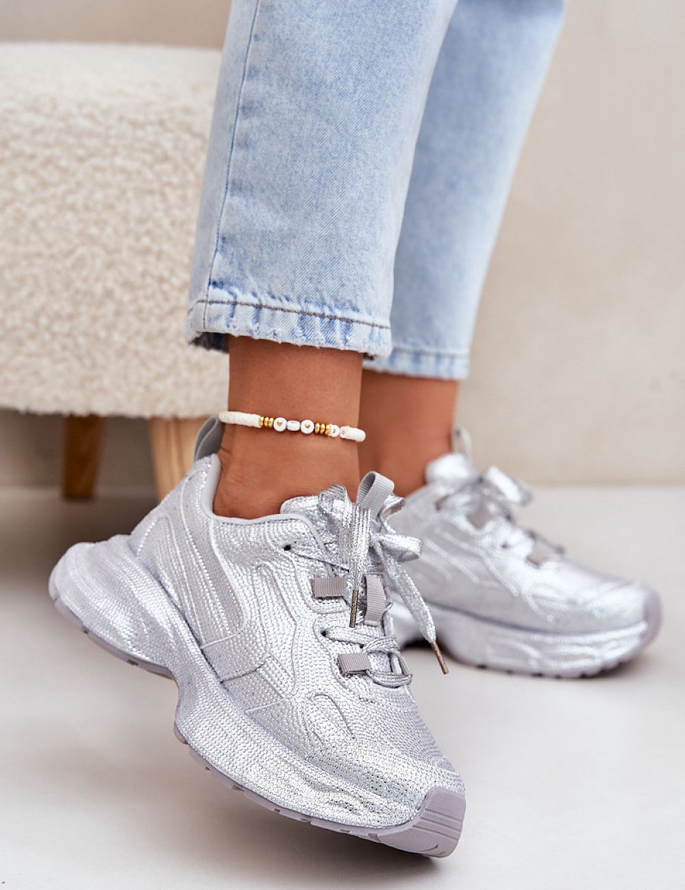 Woman wearing glittered Ravelline platform sneakers with zircon embellishments and cushioned sole, perfect for adding glamour to casual wear.