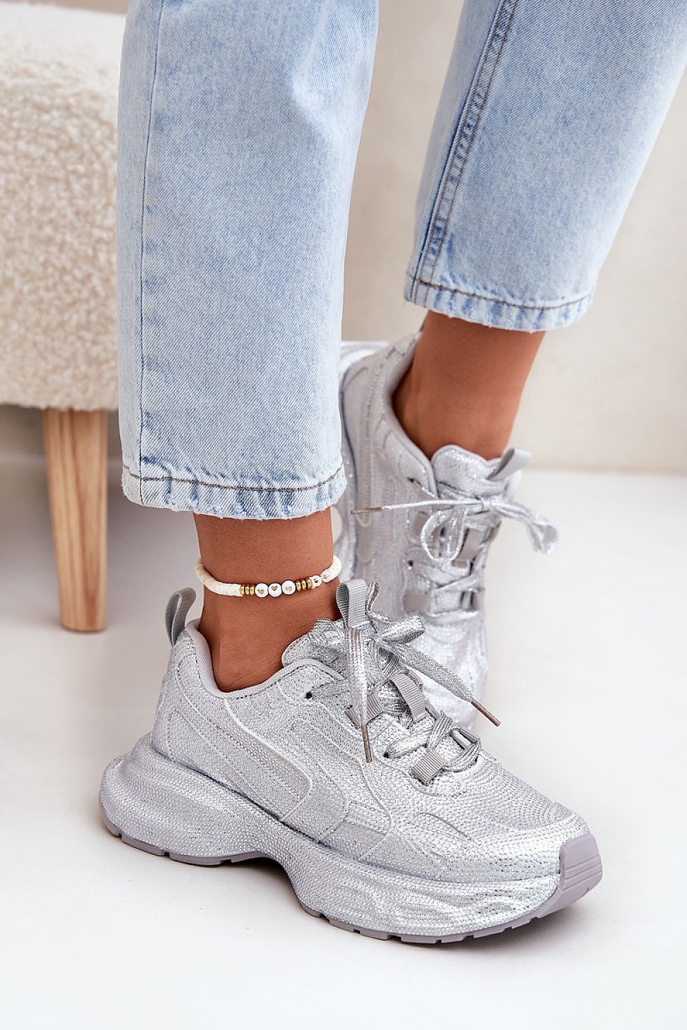 Silver glittered platform sneakers with zircon embellishments worn with light blue jeans, showcasing style and comfort for everyday wear.