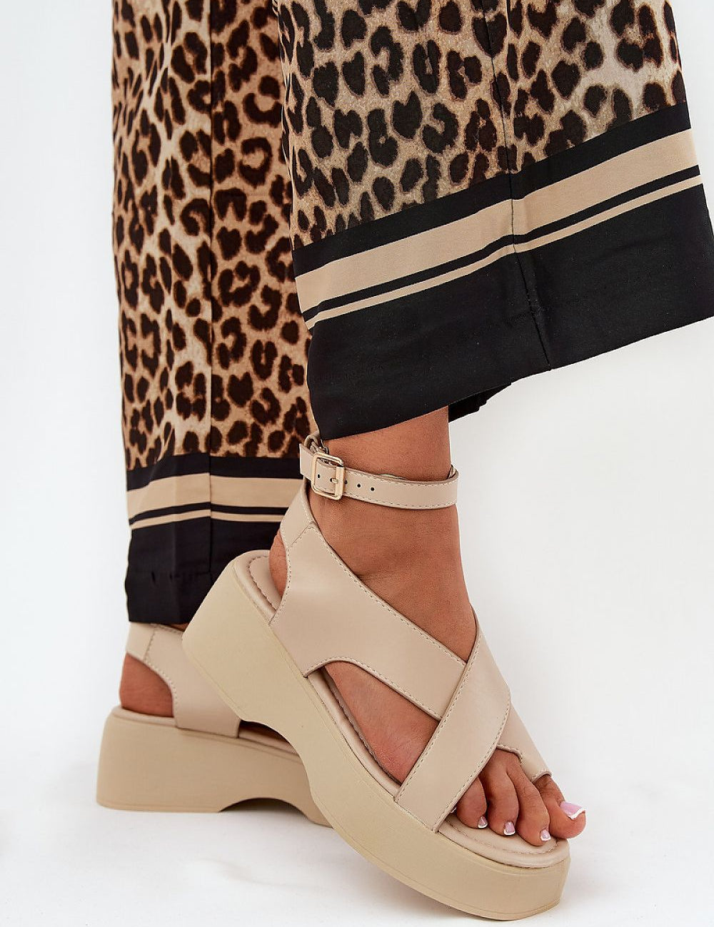 Lirianne Platform Buckle Sandals in eco leather with wedge platform and ankle strap, styled with leopard print pants for a chic look.