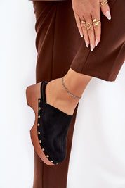 Woman wearing Corveda studded suede wedge clogs with eco suede and wedge heel, styled with brown trousers, showcasing bohemian charm.