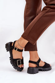 Talmera Buckled Platform Sandals with gold buckle and eco leather, ideal for warm weather styling, shown with brown trousers.