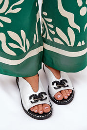 Elegant sandals with eco-leather upper and decorative front detail, worn with green flowing trousers, showcasing a refined summer look.