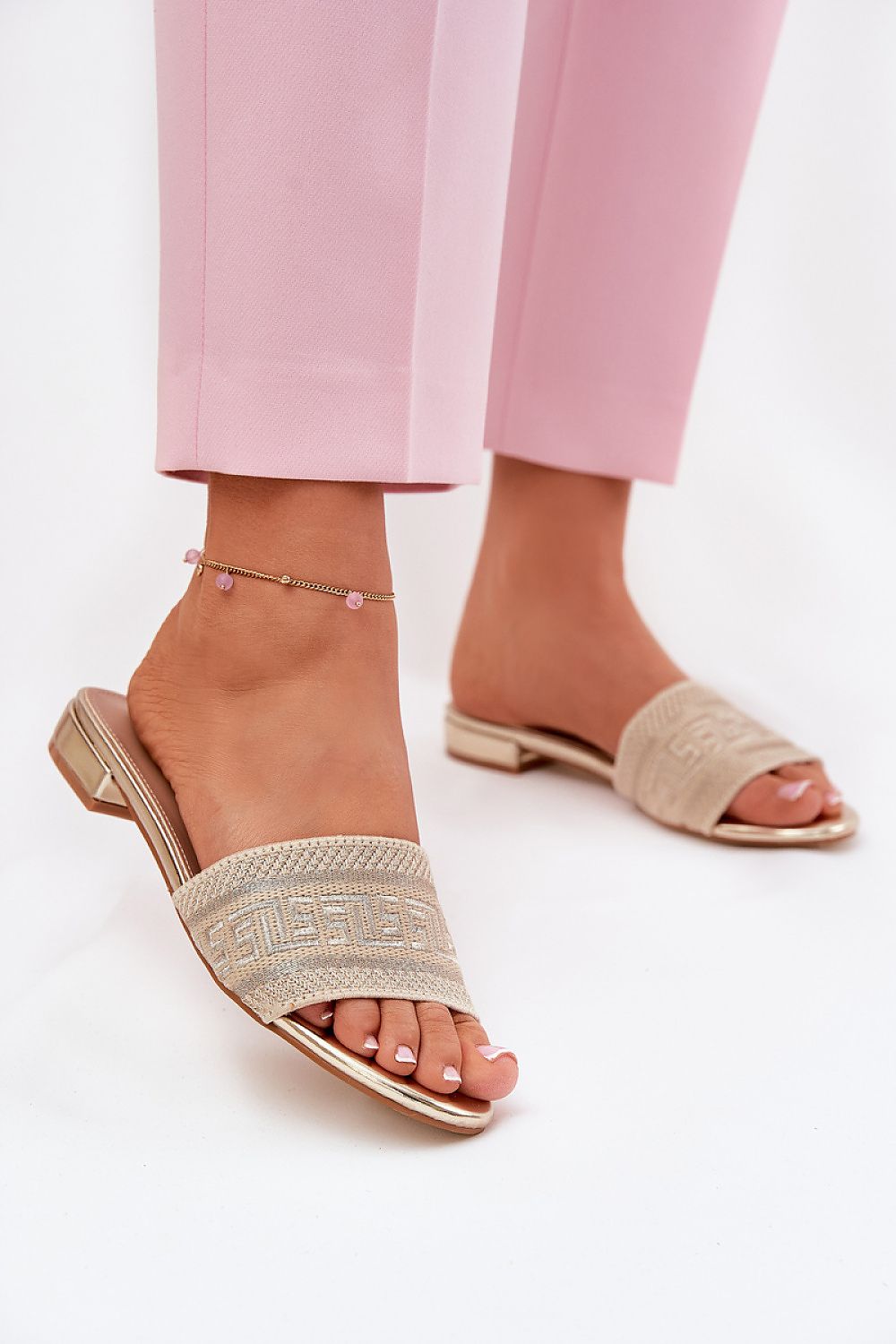 Arelia Flat Summer Slides featuring breathable textile upper and eco-leather insole, perfectly paired with pink pants for warm days.