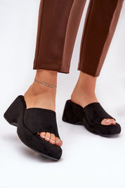 Woman wearing Zalhera Elevated Textile Wedge Sandals in black with suede-like finish, open-toe style and high platform.