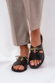 Alvessa Gold Accent Leather Slides with delicate golden string detail and minimalist design, worn with beige trousers.