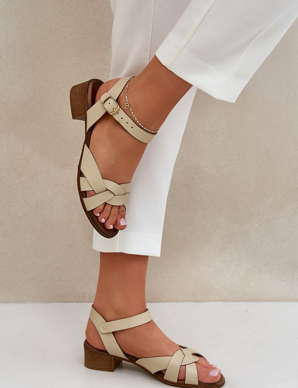 Valerinne cross-strap leather sandals with low block heel, featuring soft natural leather and refined crossover straps.