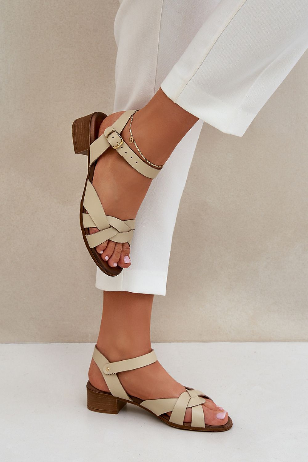 Valerinne cross-strap leather sandals with low block heel, featuring soft natural leather and refined crossover straps.