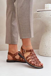 Woman wearing Celira Flat Leather Sandals with ankle strap and buckle, showcasing casual elegance and genuine leather craftsmanship.