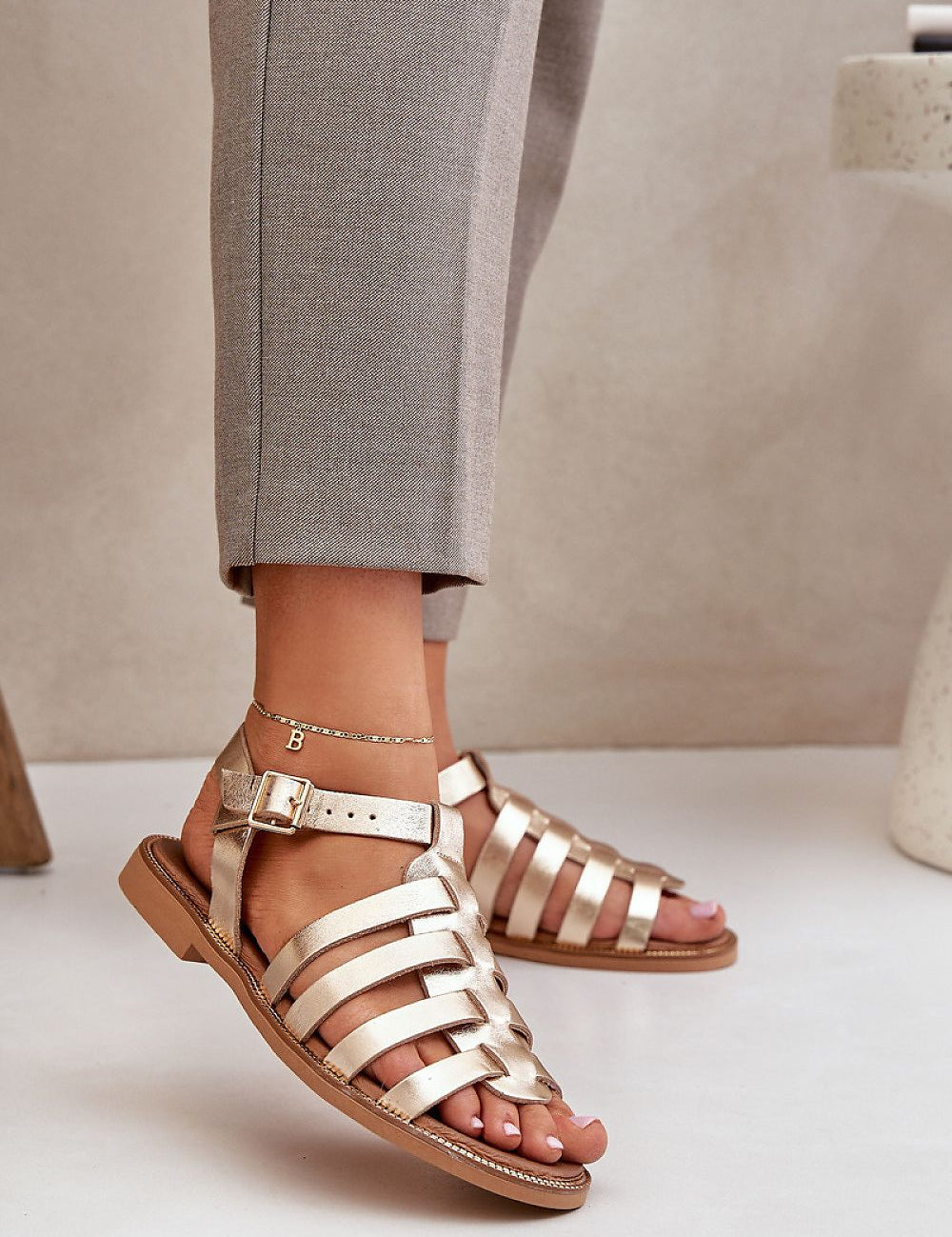 Stylish flat leather sandals with ankle buckle, perfect for casual or formal occasions.