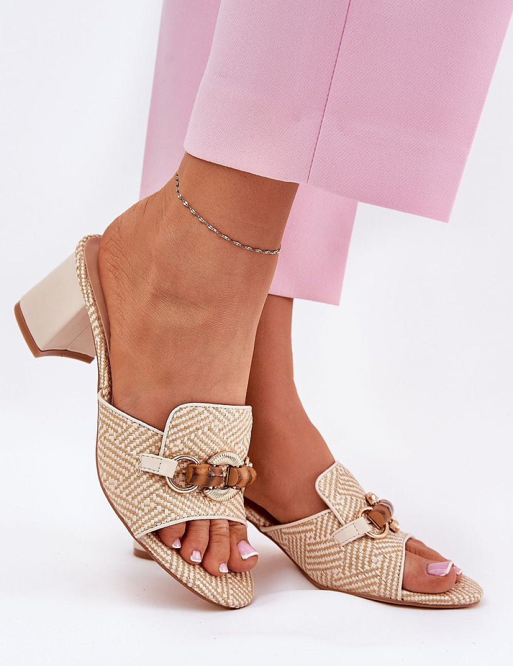 Mireta woven slip-heel sandals with intricate pattern, sculptural design, and pillar heel, perfect for summer fashion and casual outings.