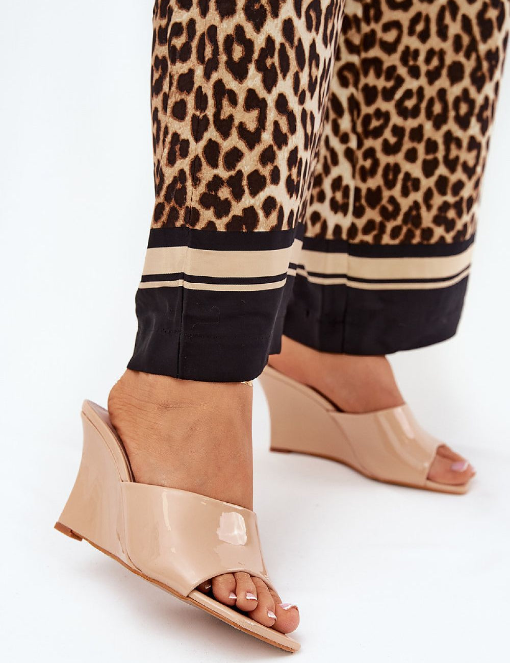 Model wearing Solena Slip-On Summer Clogs in eco leather with wedge heel, styled with leopard print trousers, showcasing open-toe design.