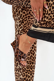 Woman wearing leopard print pants and open-toe slip-on clog with eco leather finish, showcasing summer footwear fashion.