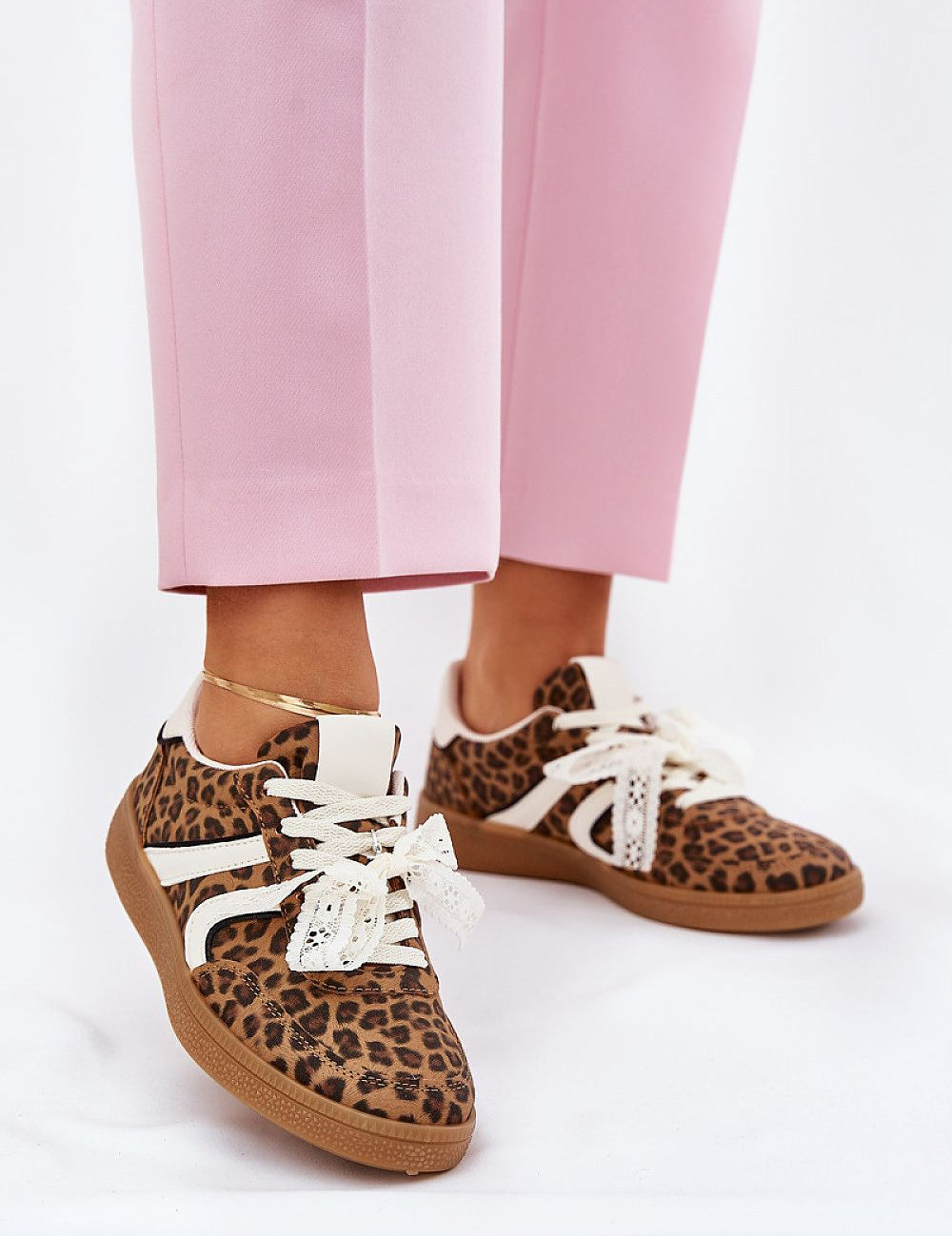 Model wearing pink pants with leopard print sneakers featuring white laces and a lace accent, showcasing Zyrmira's stylish design.