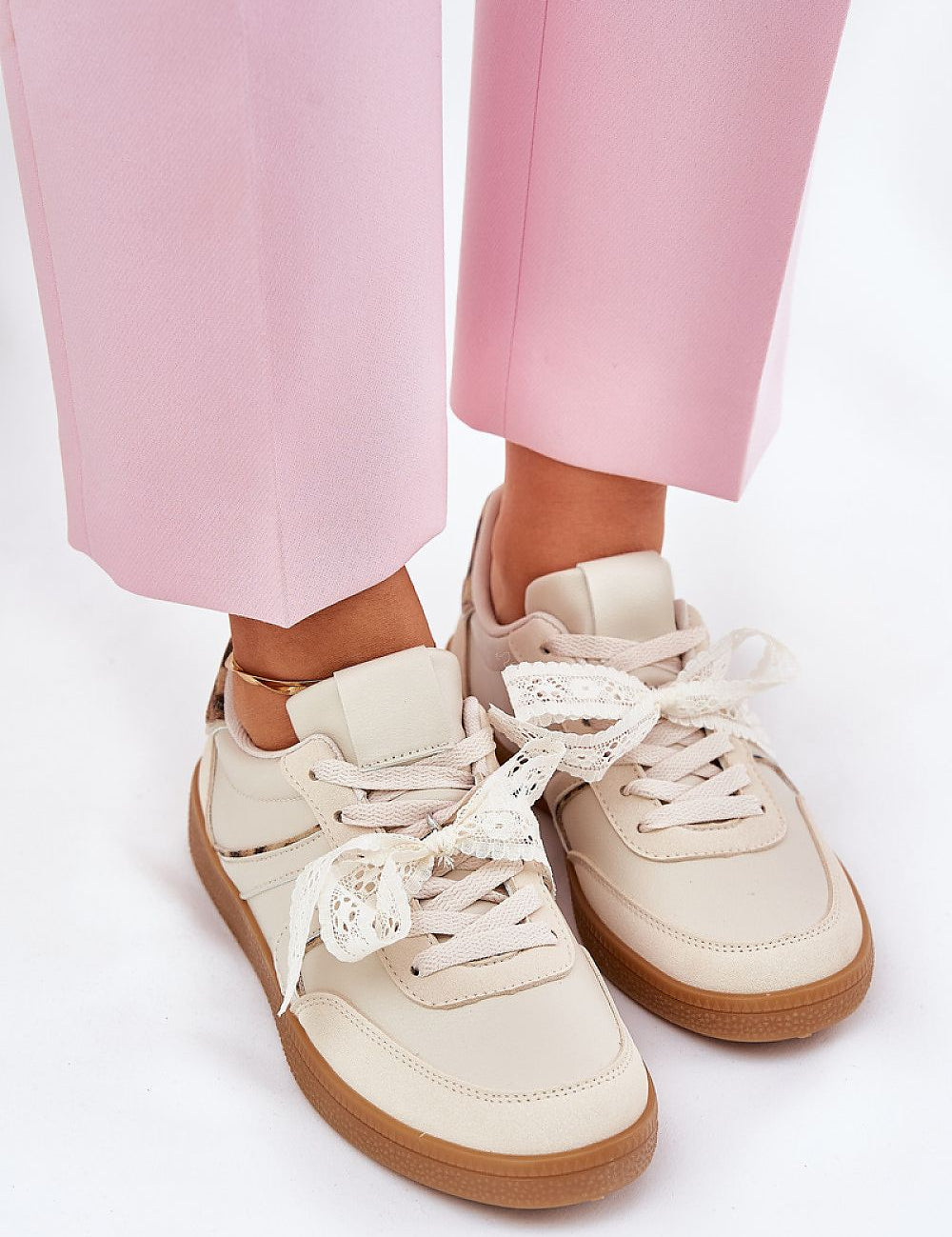 Woman wearing Zyrmira Custom Lace Sport Sneakers with pink pants, showcasing eco leather material and detachable lace detail.