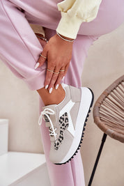 Woman wearing Olivelle Wrapped Front Platform Shoes with suede-texture and leopard pattern, styled with pink pants.